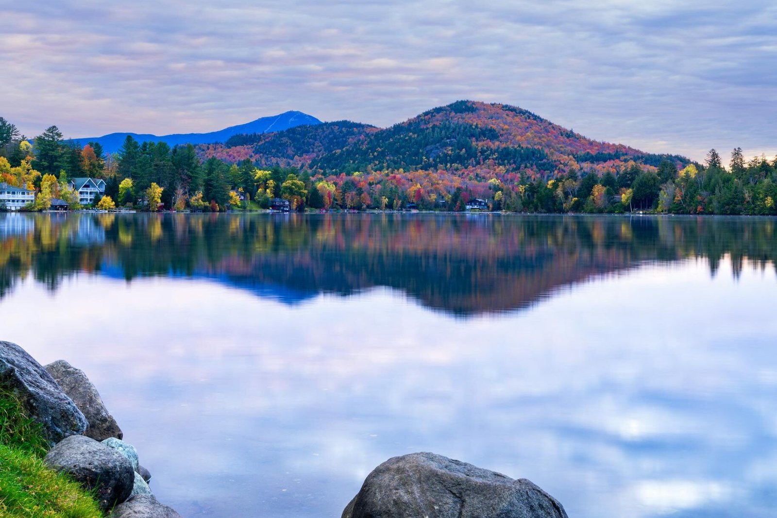 Tranquil Mirror Lake reflecting autumn foliage and mountains in the Adirondacks.